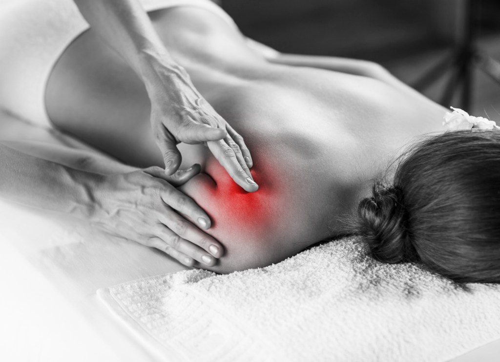 Woman on massage couch having a shoulder treatment. 
